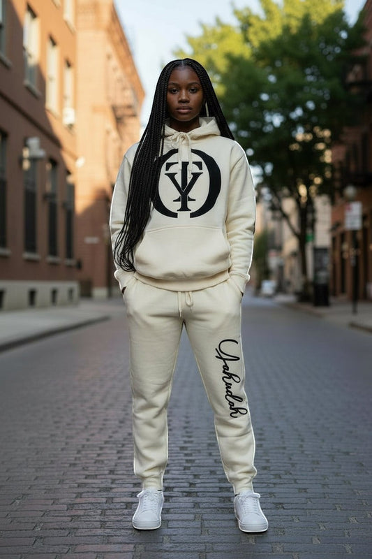 YAHUDAH COLLECTION cream fleece jogger sweatpants set with hoodie and drawstring waist. Model wears white sneakers.
